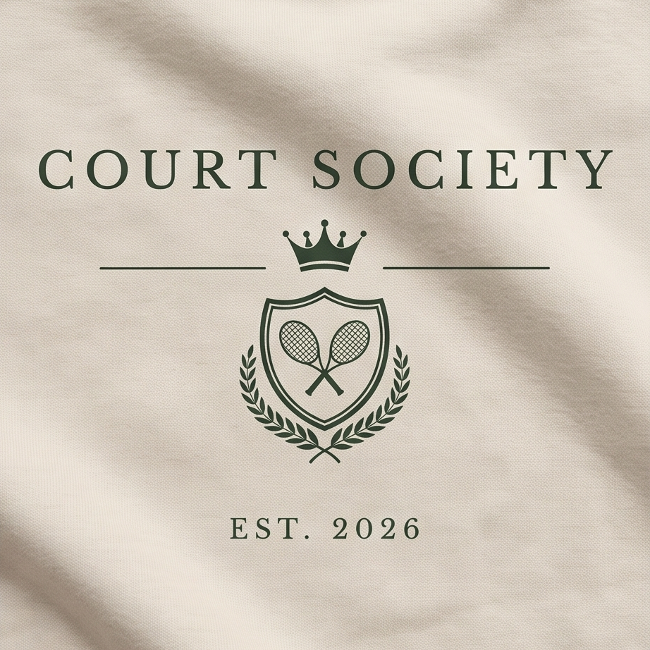 Close-up of a cream-colored fabric surface with dark green printed text reading 'COURT SOCIETY' and 'EST. 2026' around a crest emblem with a crown, tennis rackets, and laurel branches.