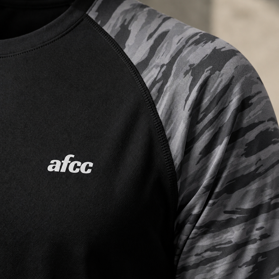 Black and camouflage long-sleeve shirt with 'afcc' logo on black background