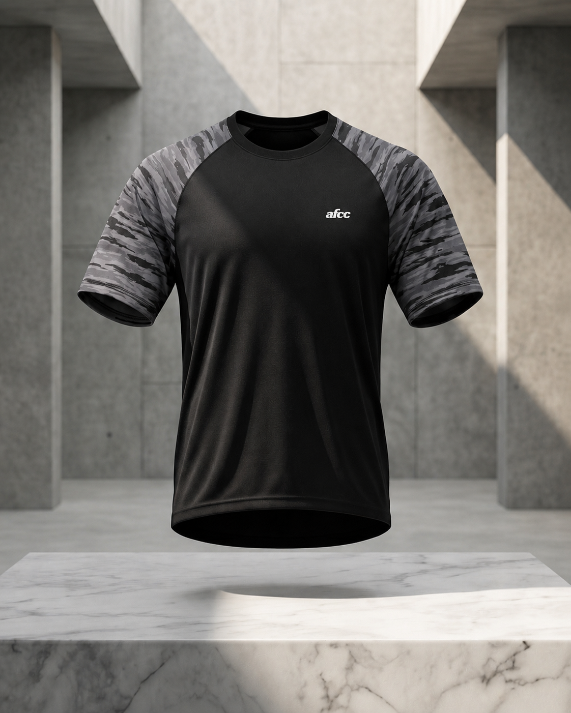 Black athletic shirt with gray sleeves on a marble surface and concrete wall background