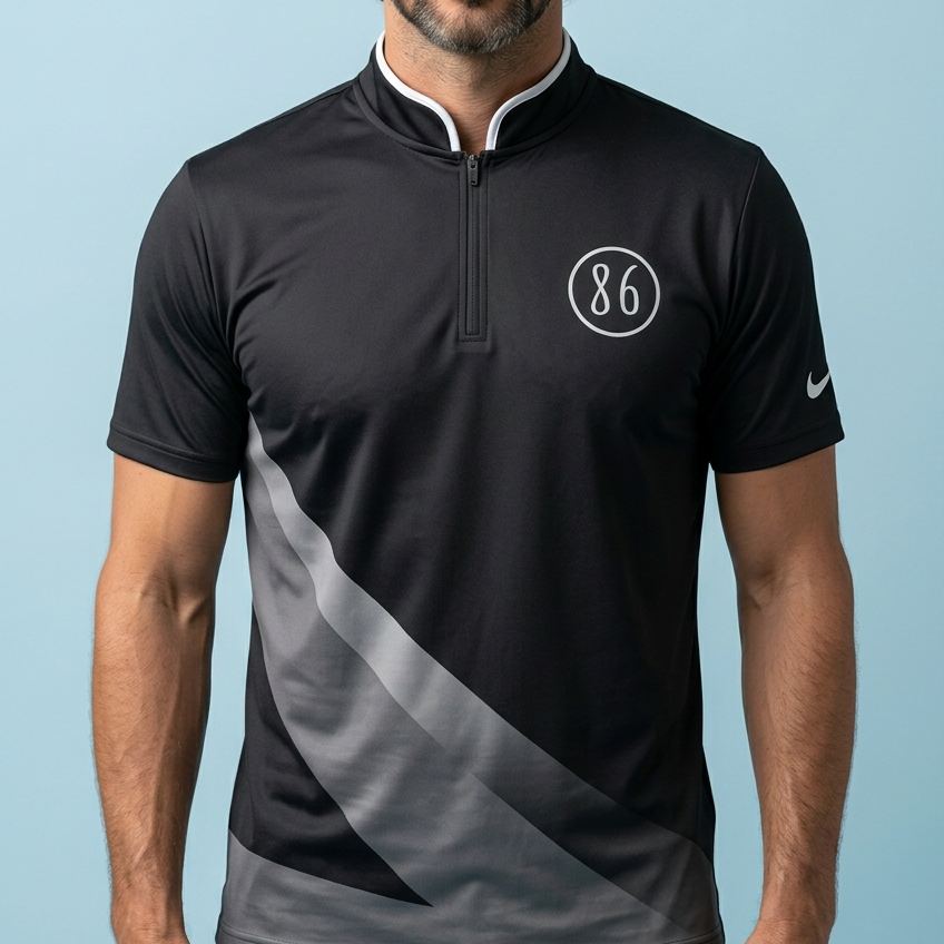 Man wearing a black and gray sports shirt with a logo on a light blue background