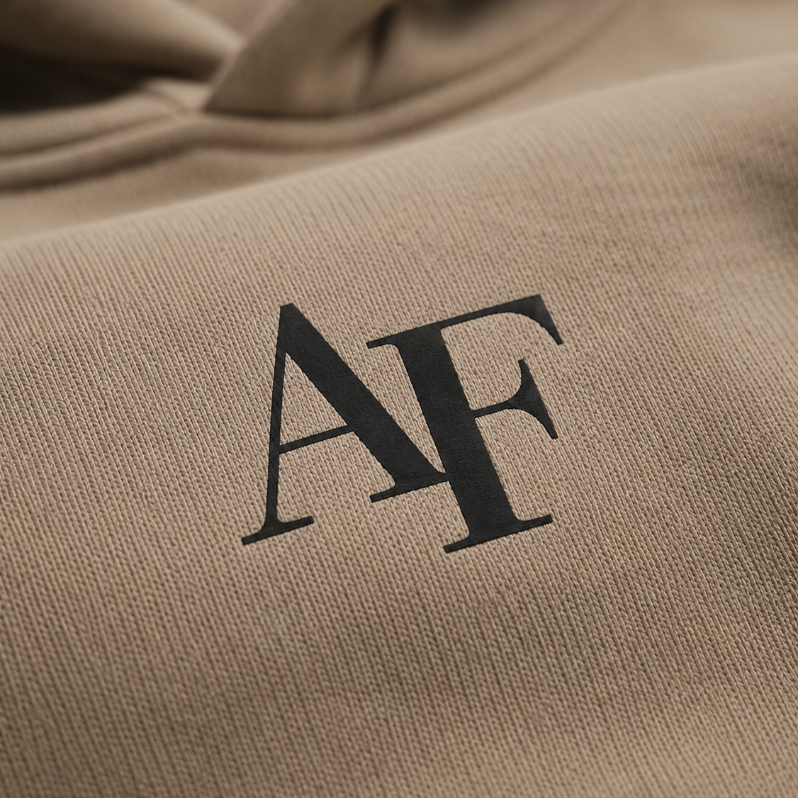 Close-up of a beige fabric with 'AF' initials embroidered on it.
