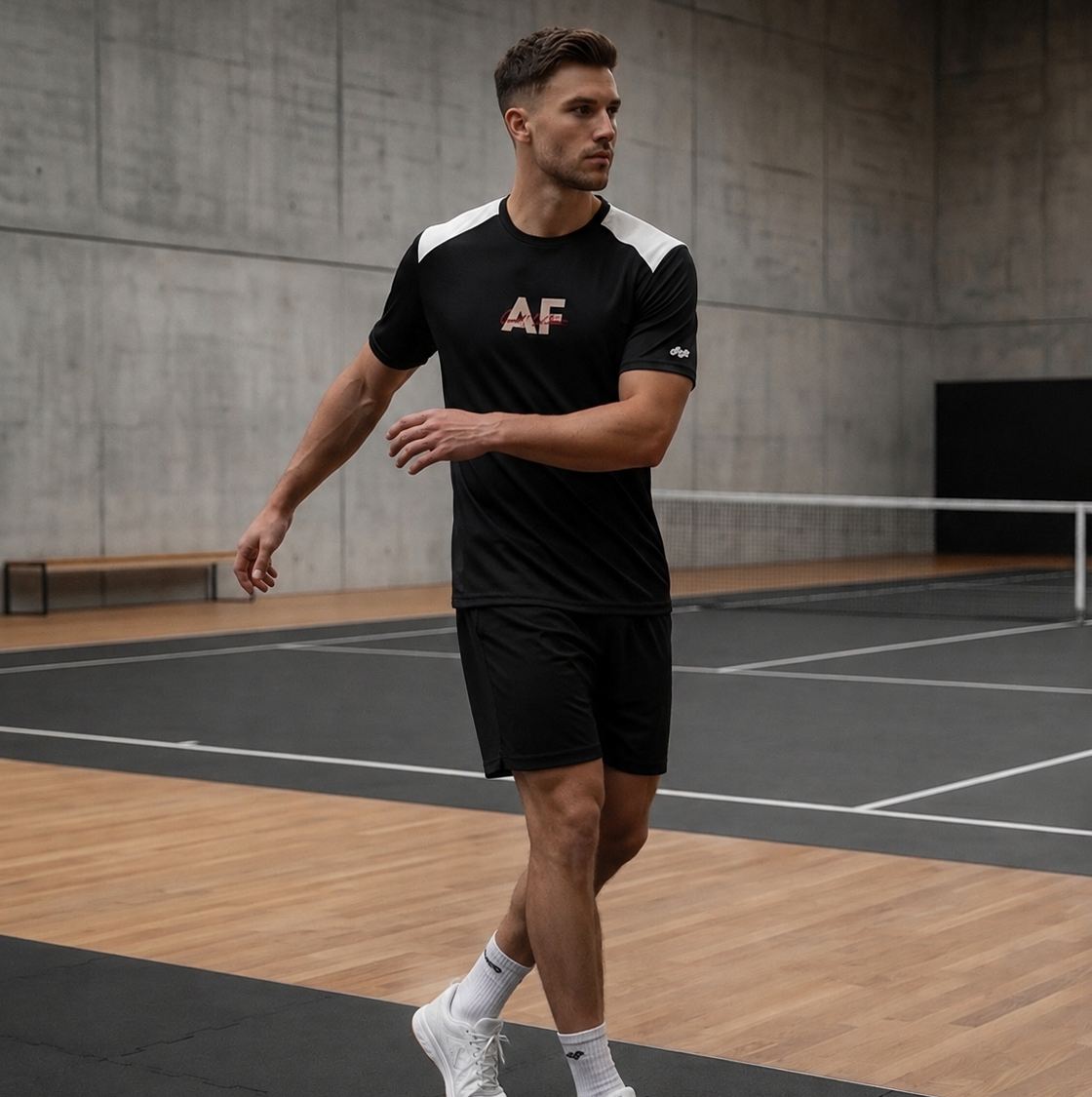 Man wearing a black sports outfit with 'AF' logo on a tennis court