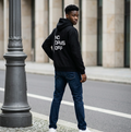 Person wearing a black hoodie with 'NO DAYS OFF' text, standing on a street.