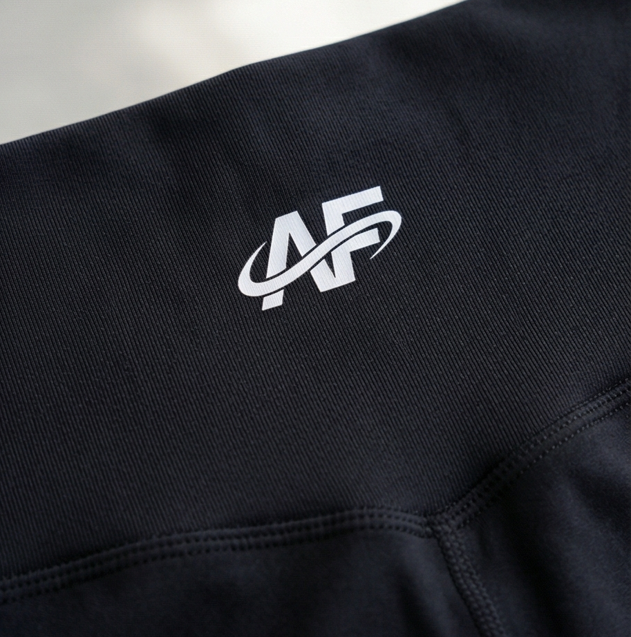 Black legging with a white logo on a light gray background