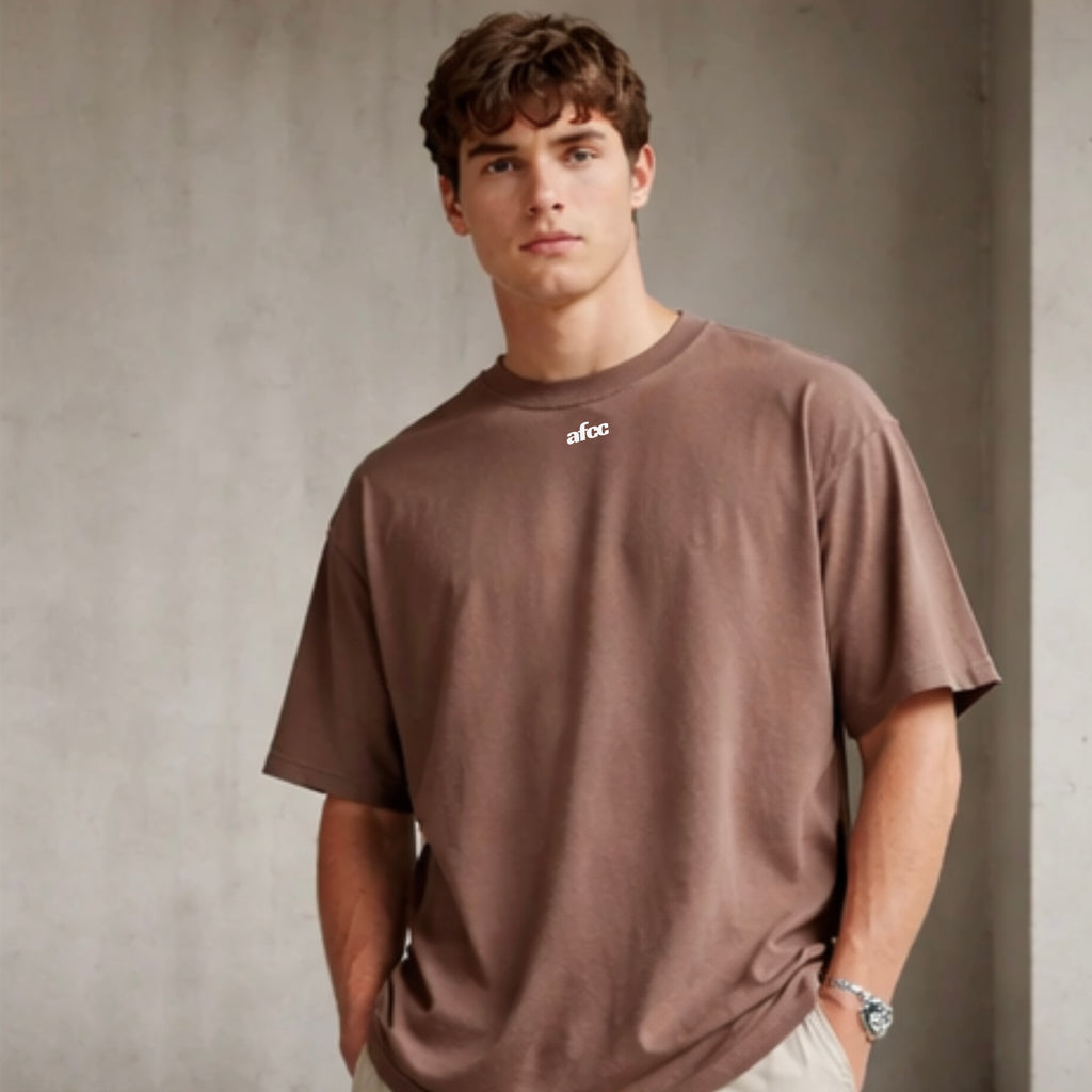 Man wearing a brown t-shirt with 'afcc' logo against a plain background