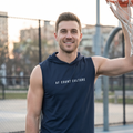Man wearing a navy sleeveless hoodie with 'AF Court Culture' text on an outdoor basketball court.