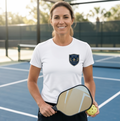 Woman holding a pickleball paddle and ball on a court