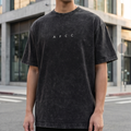 Person wearing a black t-shirt with 'AFCC' logo in an urban setting