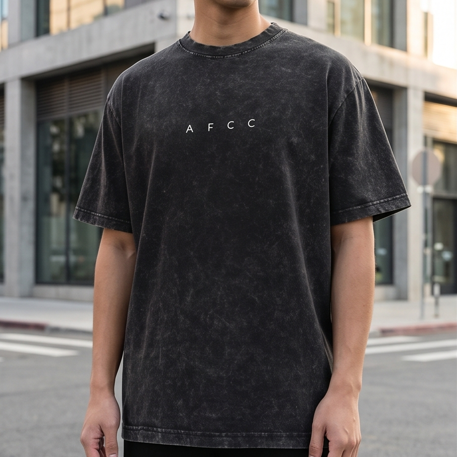 Person wearing a black t-shirt with 'AFCC' logo in an urban setting
