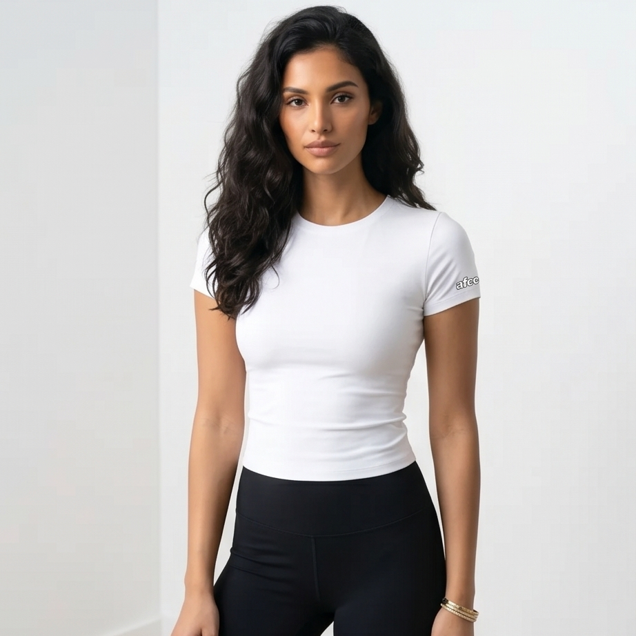 Woman wearing a white t-shirt and black leggings against a plain background