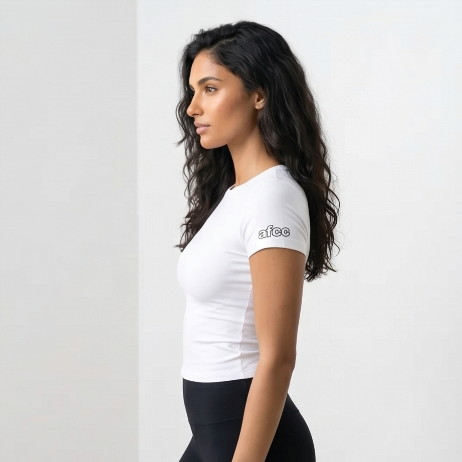 Woman wearing a white t-shirt with a logo on a plain background