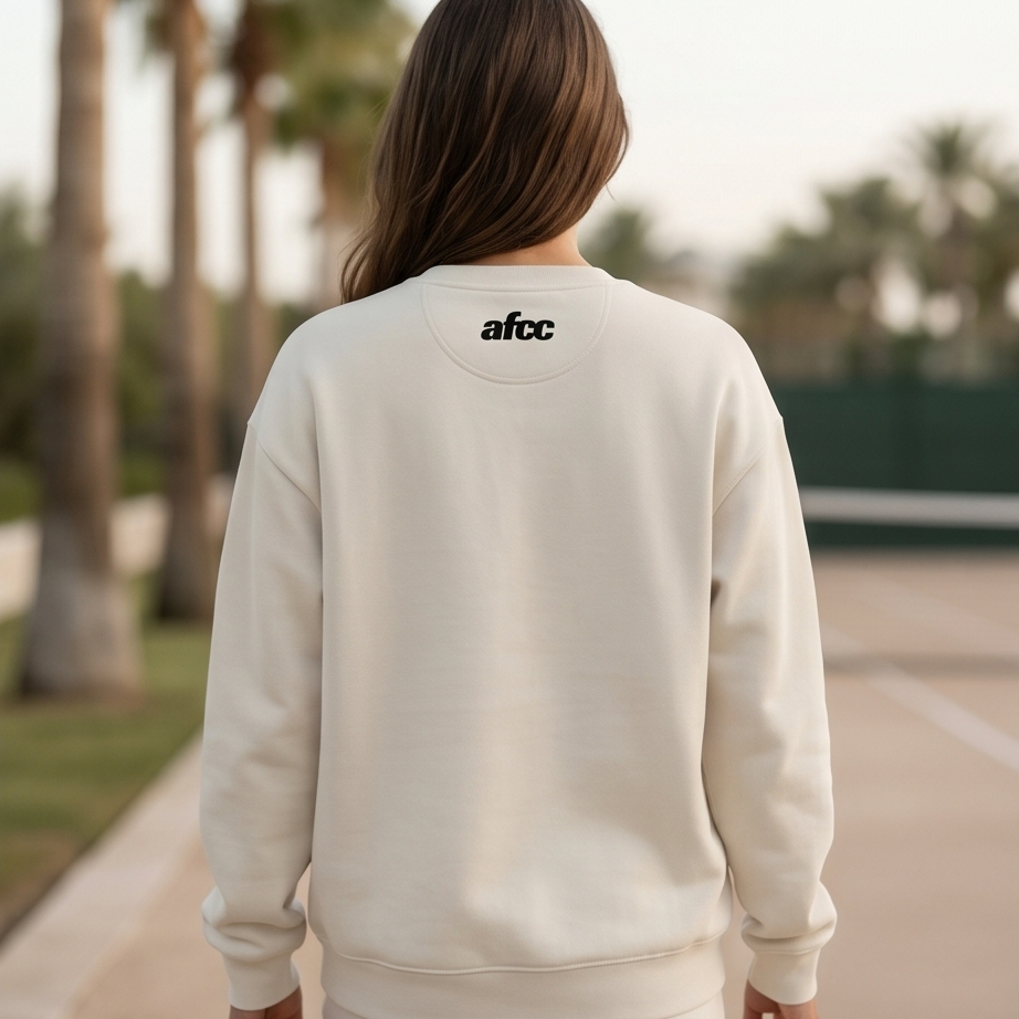 Person wearing a beige sweatshirt with 'afc' logo on the back, standing outdoors.