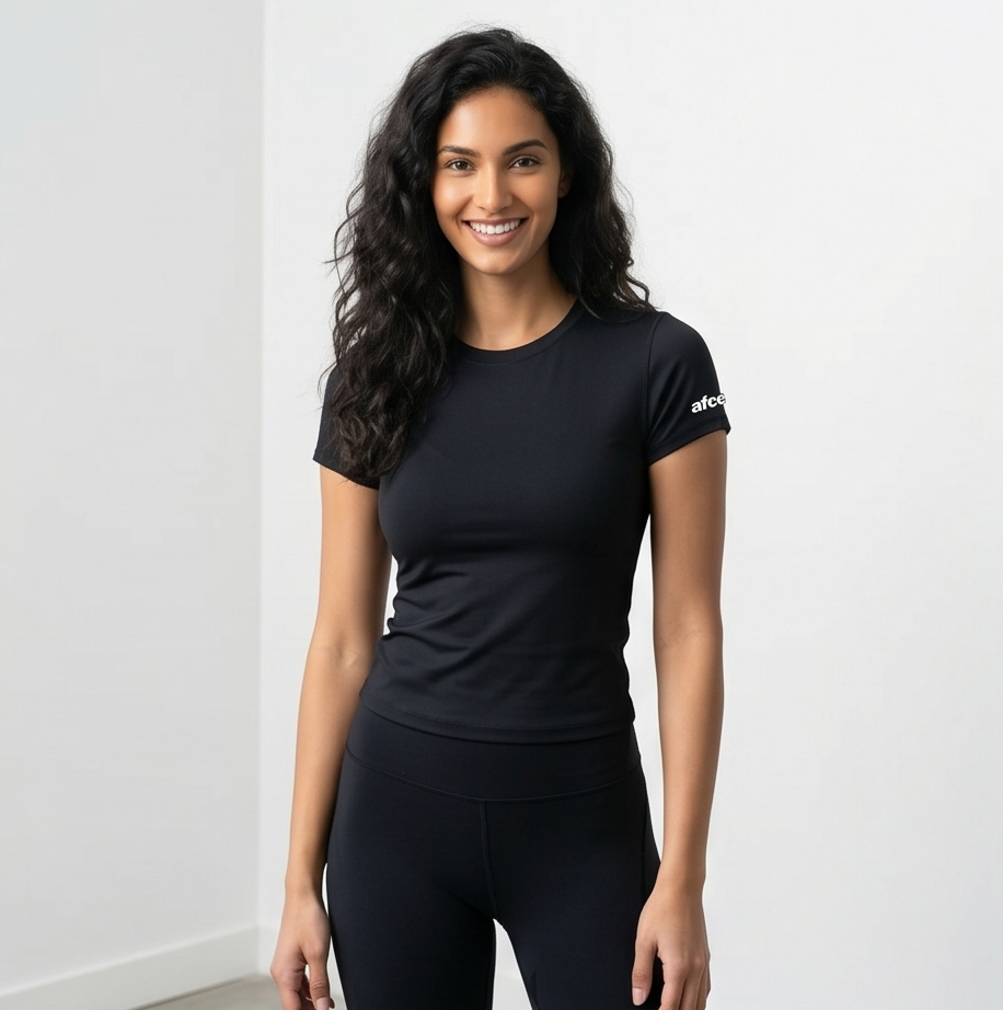 Woman wearing a black athletic outfit with a visible brand logo on a white background