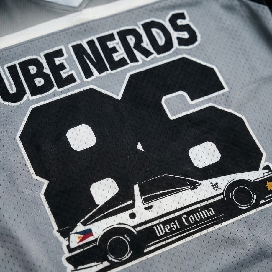Gray sports jersey with 'UBE NERDS 26' and car graphic on a black background